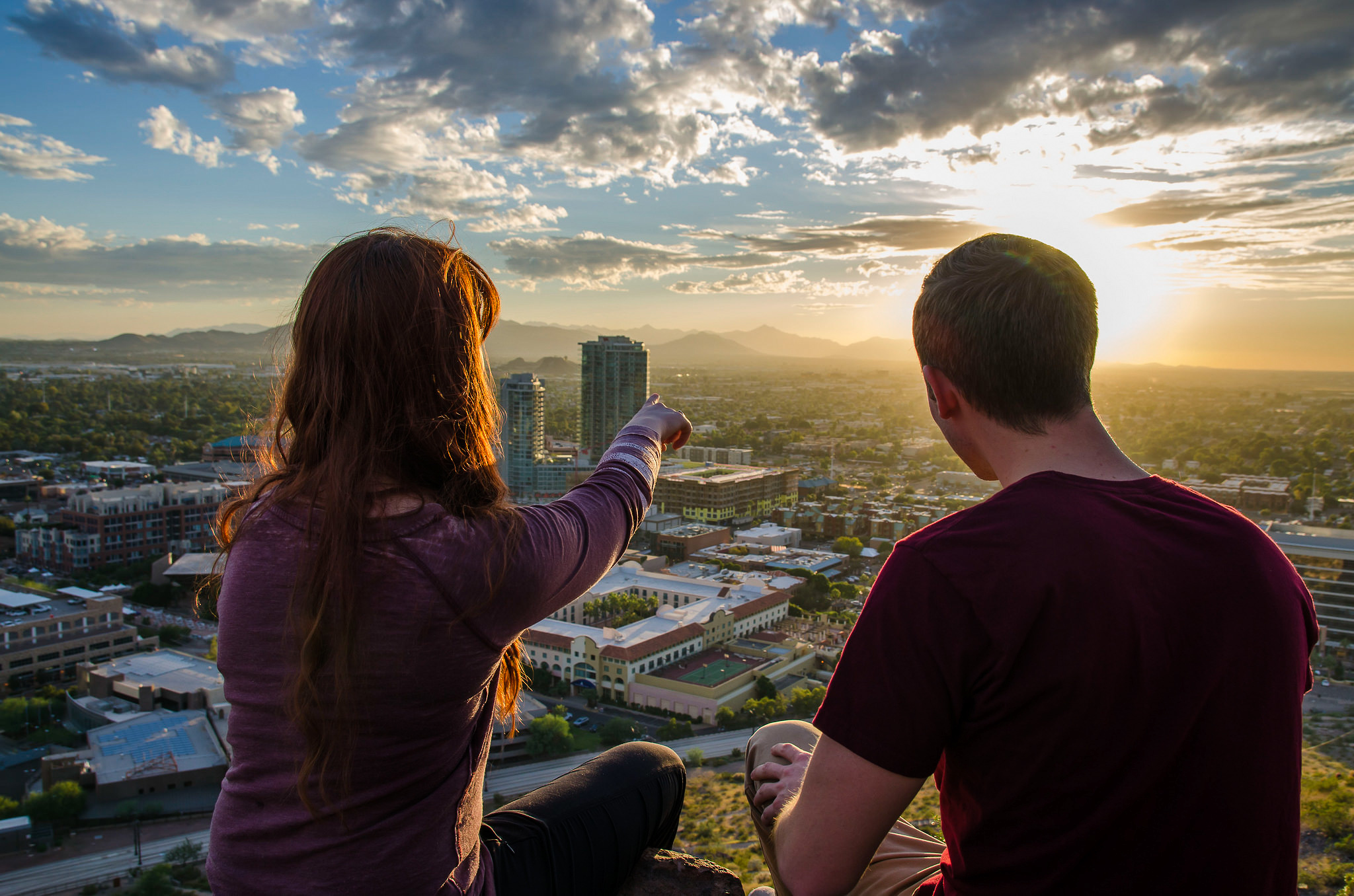 Two ASU students sitting on A Mountain, taking a selfie with their phone